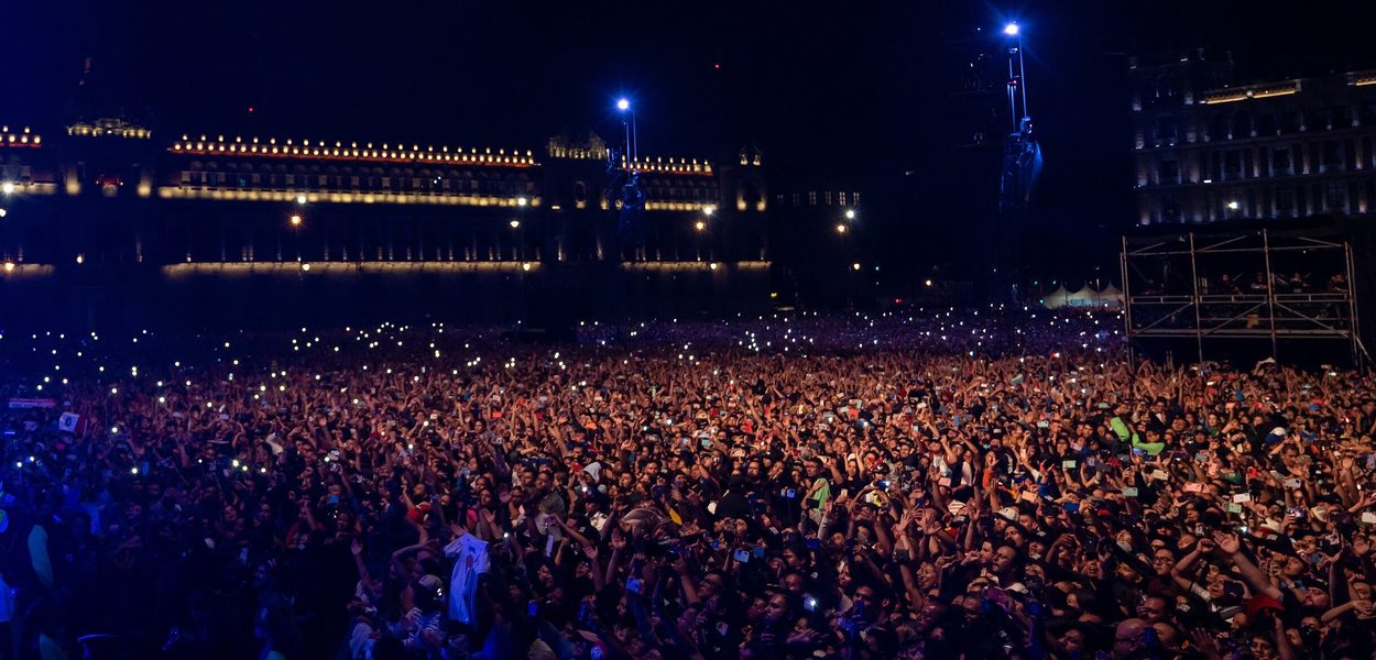 A night crowd at a public event on Mexico City’s Zocalo, lit by hundreds of raised phone screens