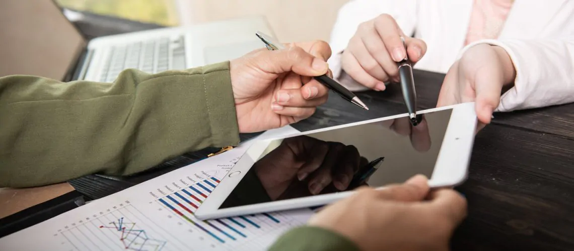 Image of two young woman business using touchpad at meeting.business team meeting to discuss statistical data presented in the form of digital graphs and charts.